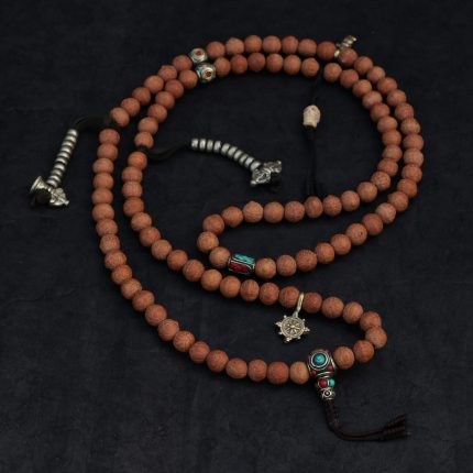 Handcrafted Nepali bodhi seed mala with phoenix eye beads, brass accents, and skull details