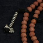 Handcrafted Nepali bodhi seed mala with phoenix eye beads, brass accents, and skull details
