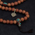 Handcrafted Nepali bodhi seed mala with phoenix eye beads, brass accents, and skull details