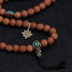 Handcrafted Nepali bodhi seed mala with phoenix eye beads, brass accents, and skull details